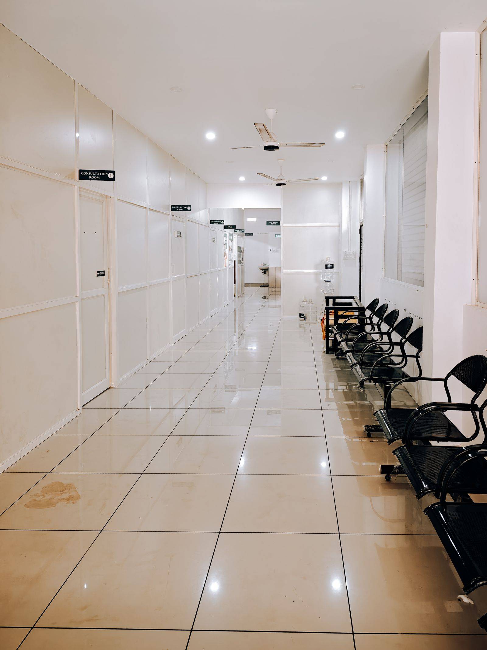 Hành lang phòng khám sàn gạch sáng với dãy ghế chờ